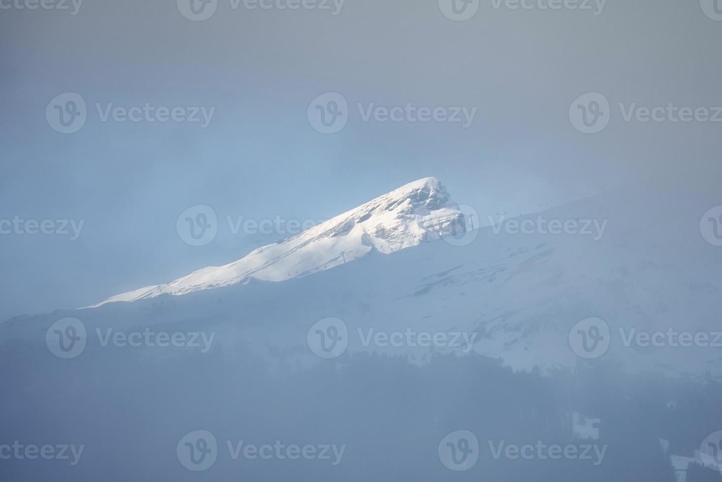 Beautiful view of snow covered Bernese alps during foggy weather photo