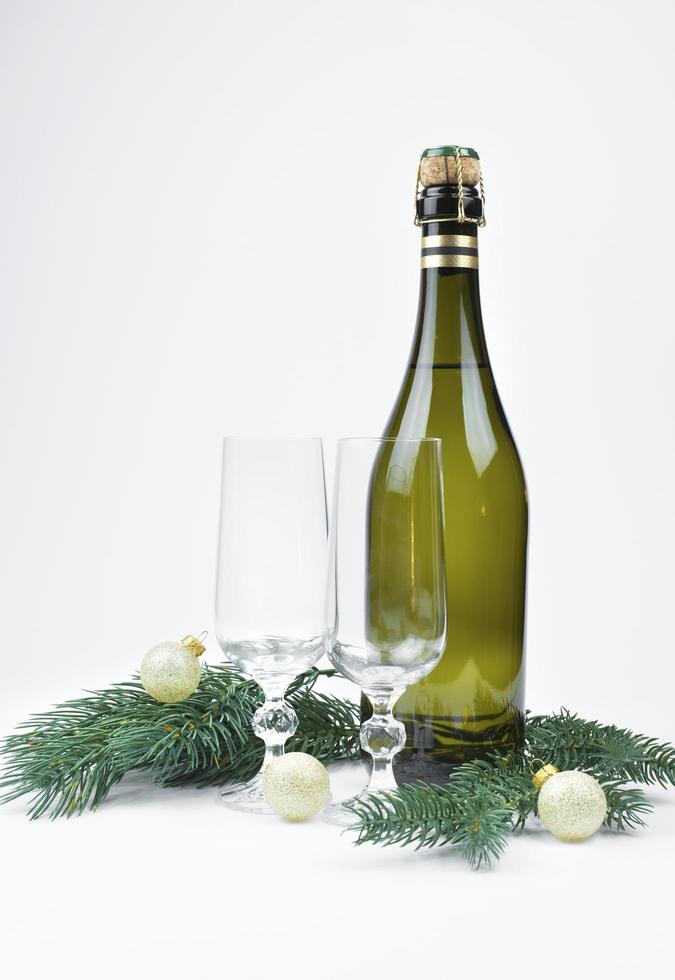 New Year's photo, a cork from champagne, a bottle of champagne , a Christmas tree whiskey, golden Christmas balls and glasses of champagne on a white background photo