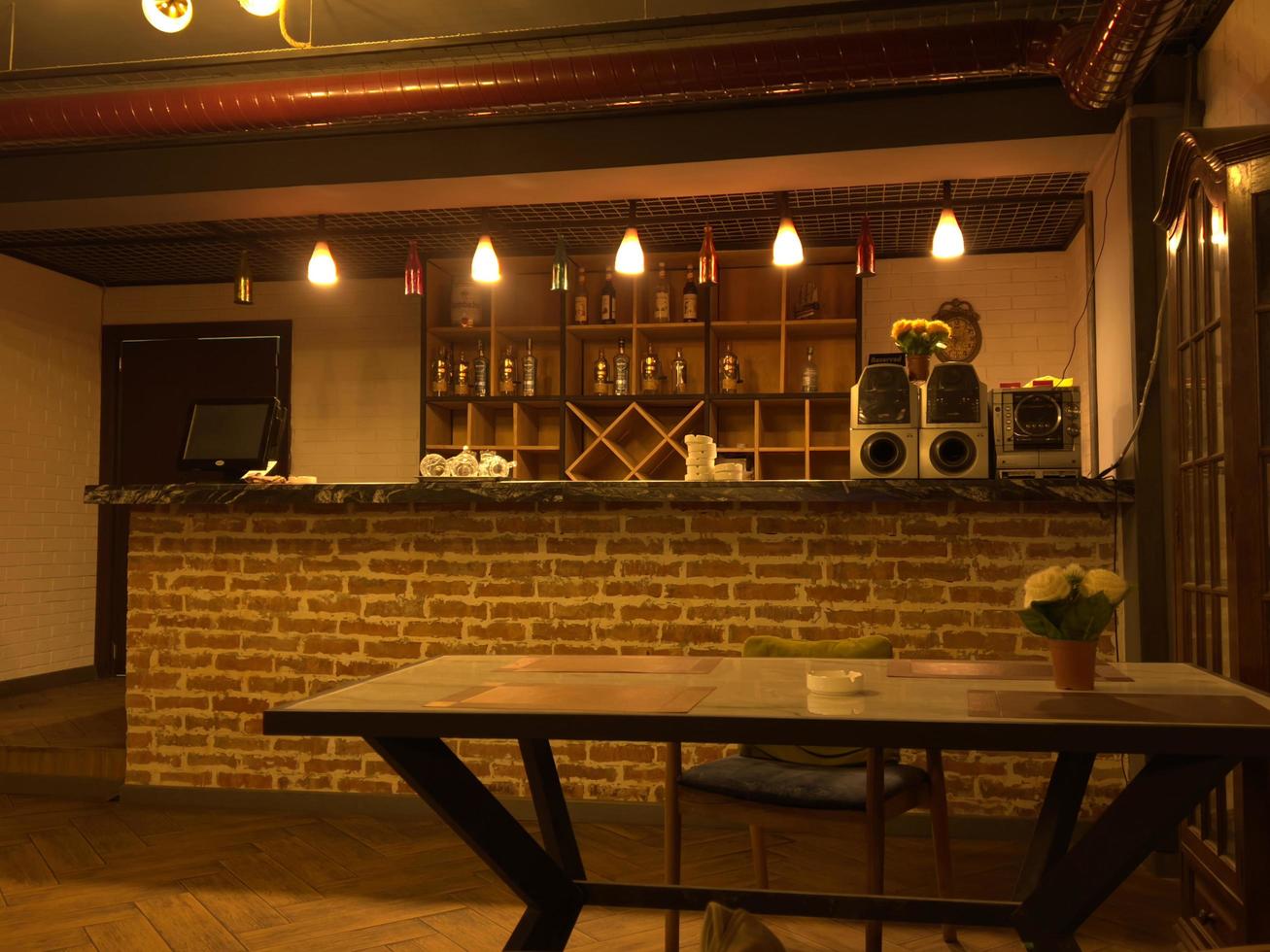 Coffee table in a restaurant with red flowers in a vase photo