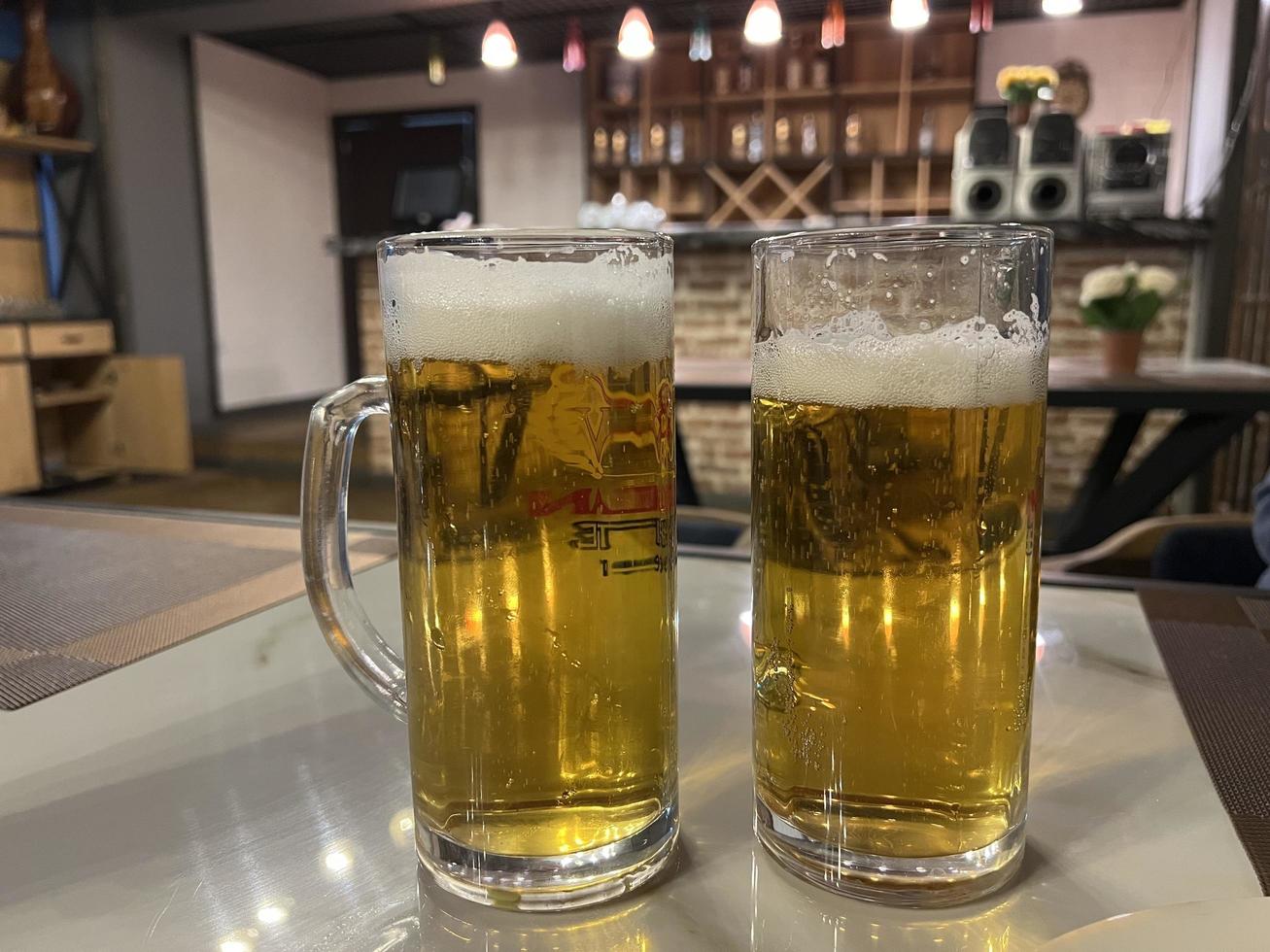 Two glasses of beer on a table in a pub or restaurant. photo
