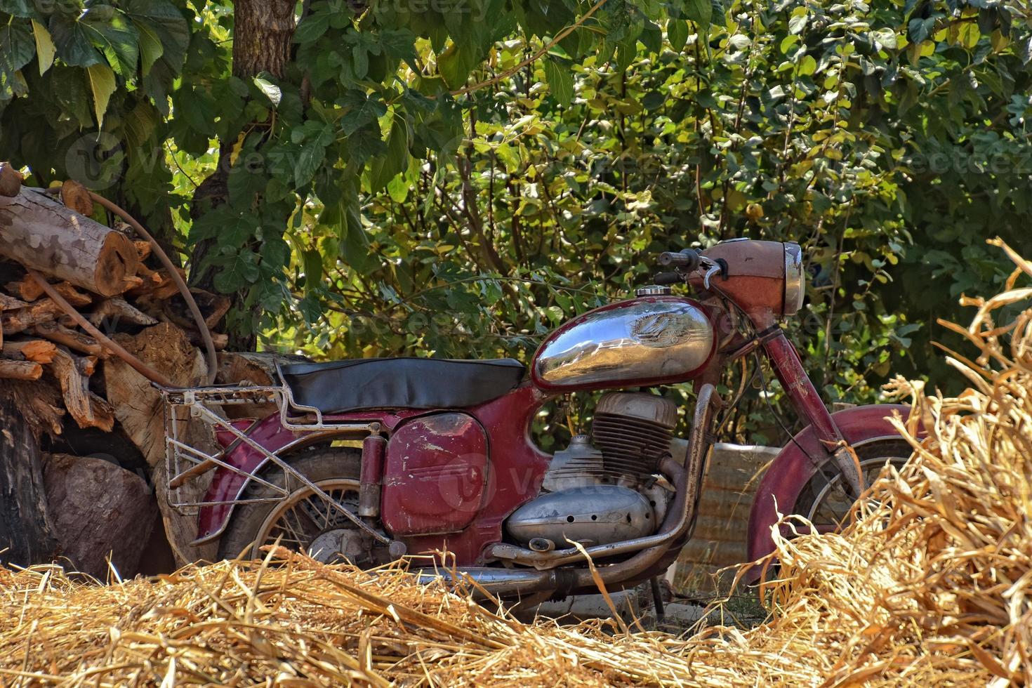 old antique motorbike in front of a turkish house hangs on a summer day photo