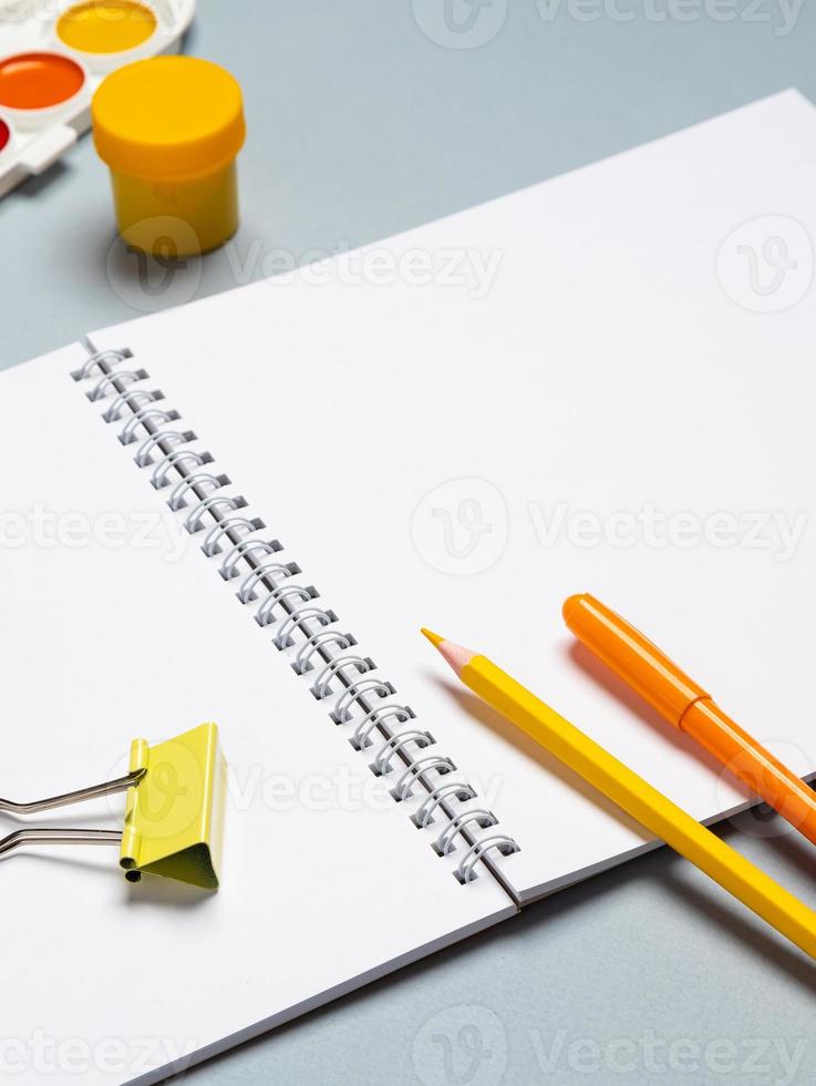 Creative flat design desktop mockup with empty notebook, stationery on blue background photo