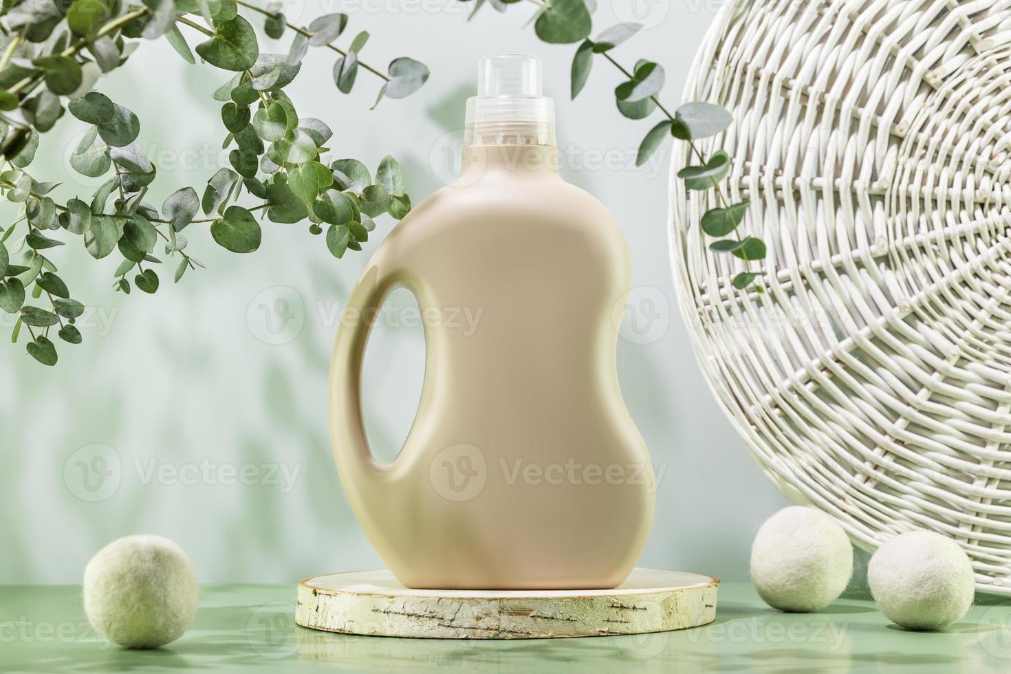 Bottle of washing gel on wooden podium with laundry balls photo