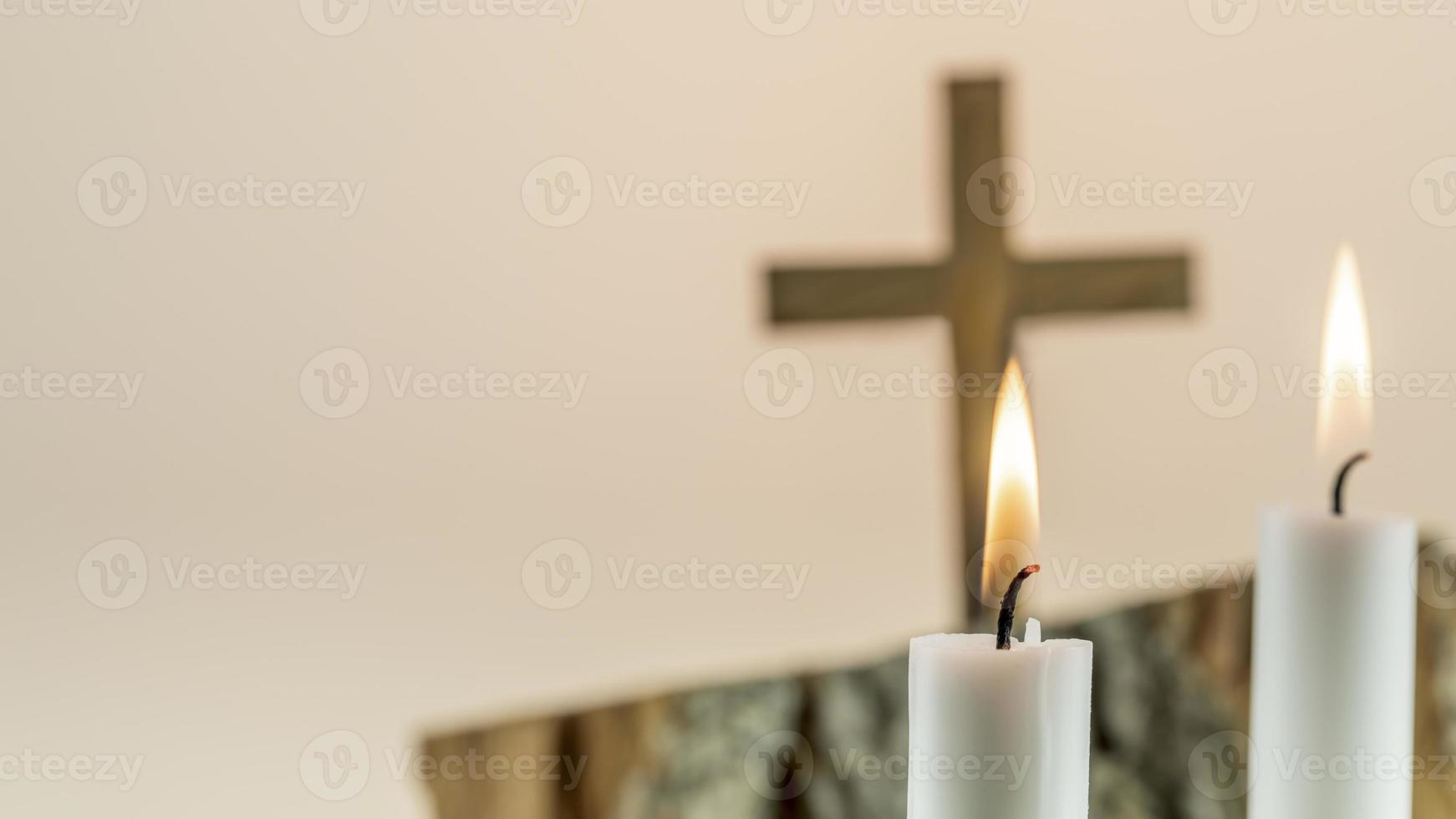 Wooden cross with white candles on gradient background with copy space. photo