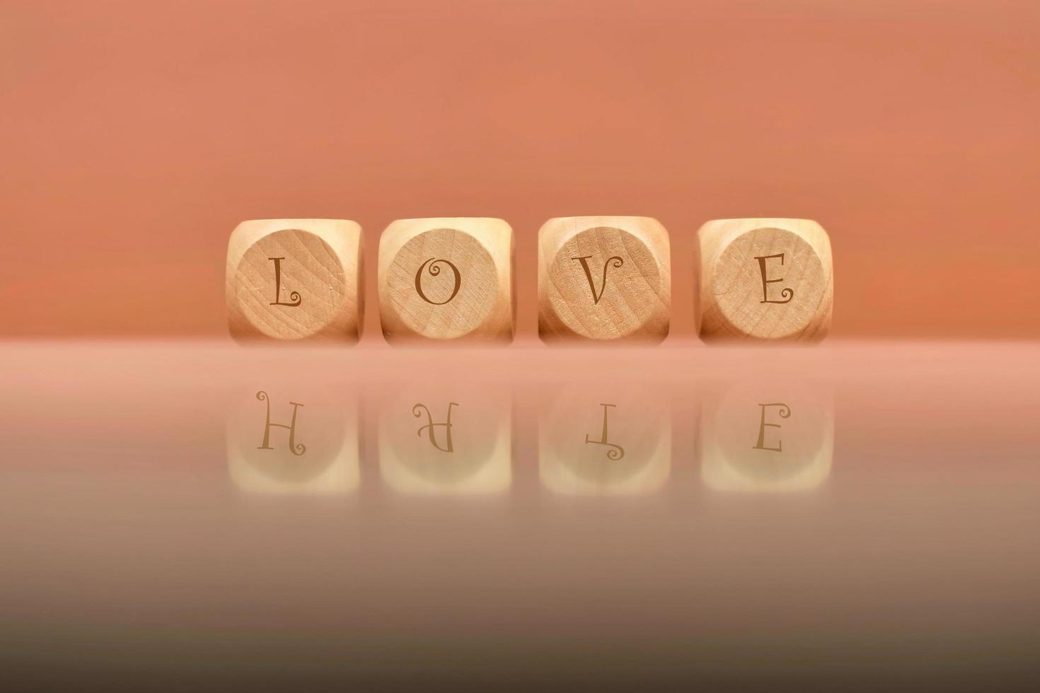 Closeup shot of wooden dices with love letters reflected in shiny surface photo