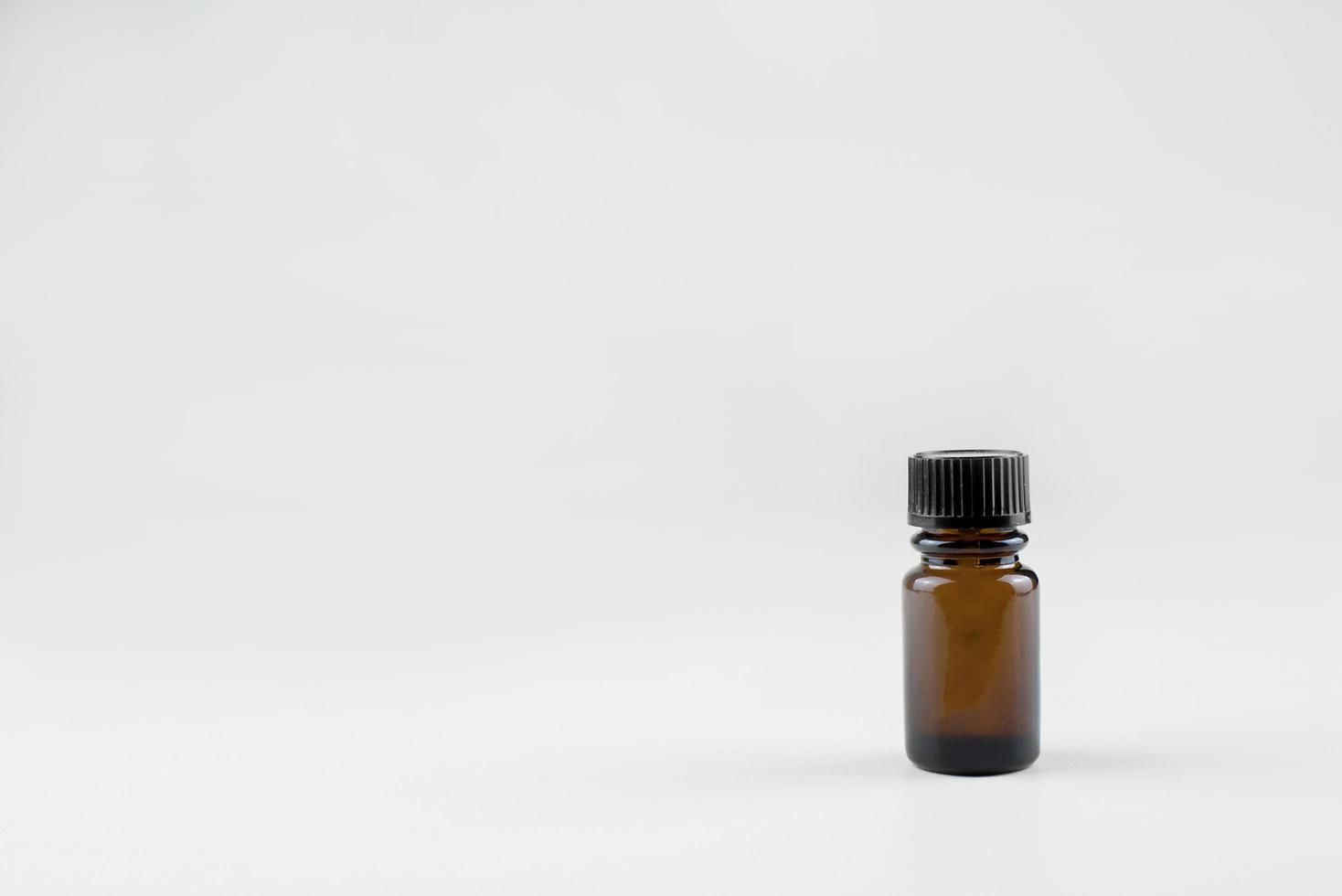 small brown glass bottle for cosmetic preparations. Bottle on a light background. photo