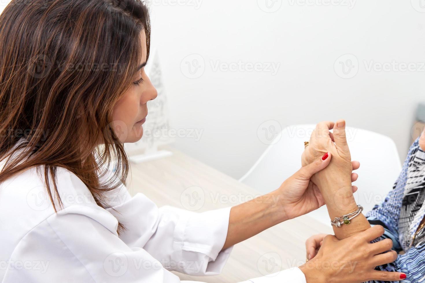 Traumatologist female doctor at her office examining a senior female patient. Skeleton bone disease exam and medic aid. Career concept. photo