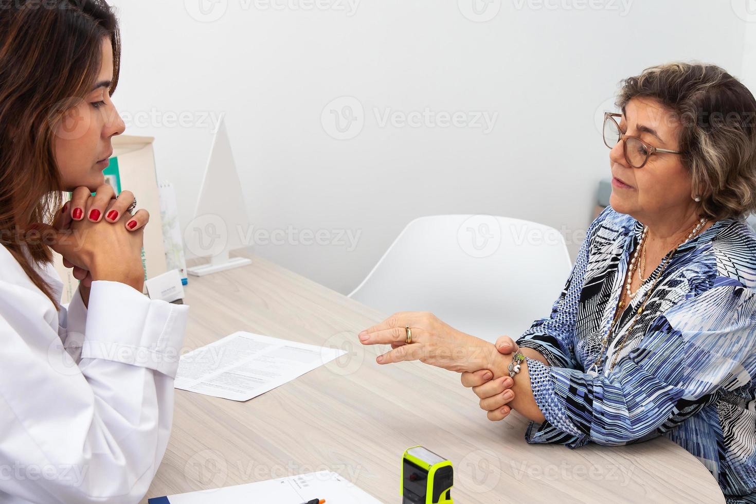 mayor hembra paciente en consulta con un traumatólogo hembra doctor. esqueleto hueso enfermedad examen y médico ayuda. seguro concepto foto