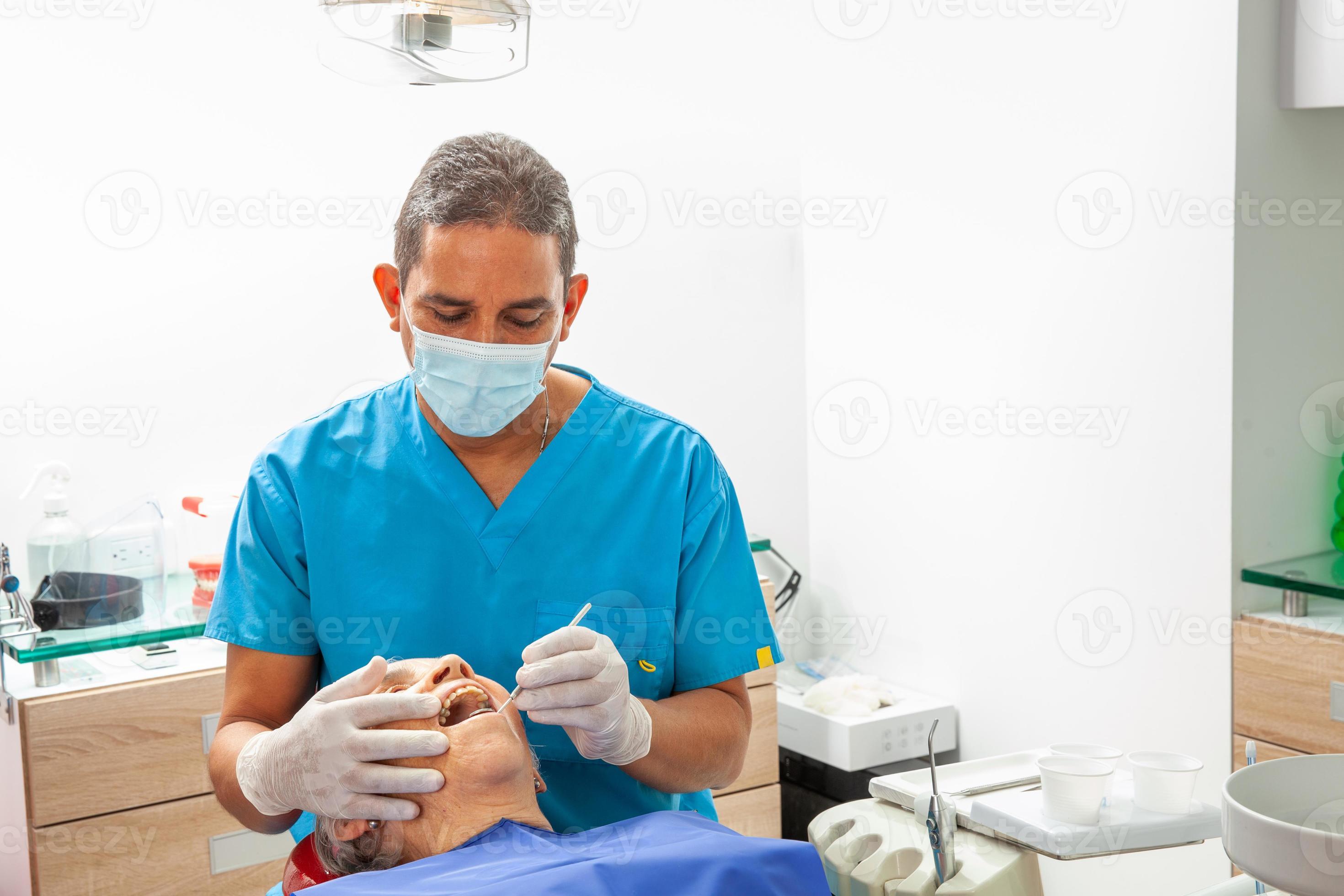 Male middle aged dentist at his office with a senior woman patient