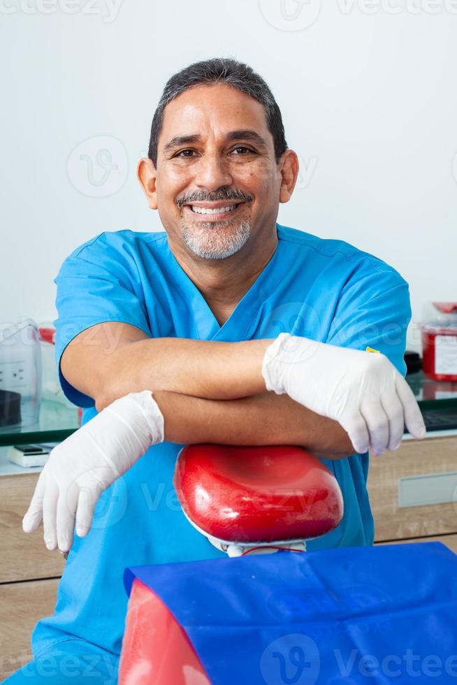 Portrait of a male middle -aged dentist at his office photo