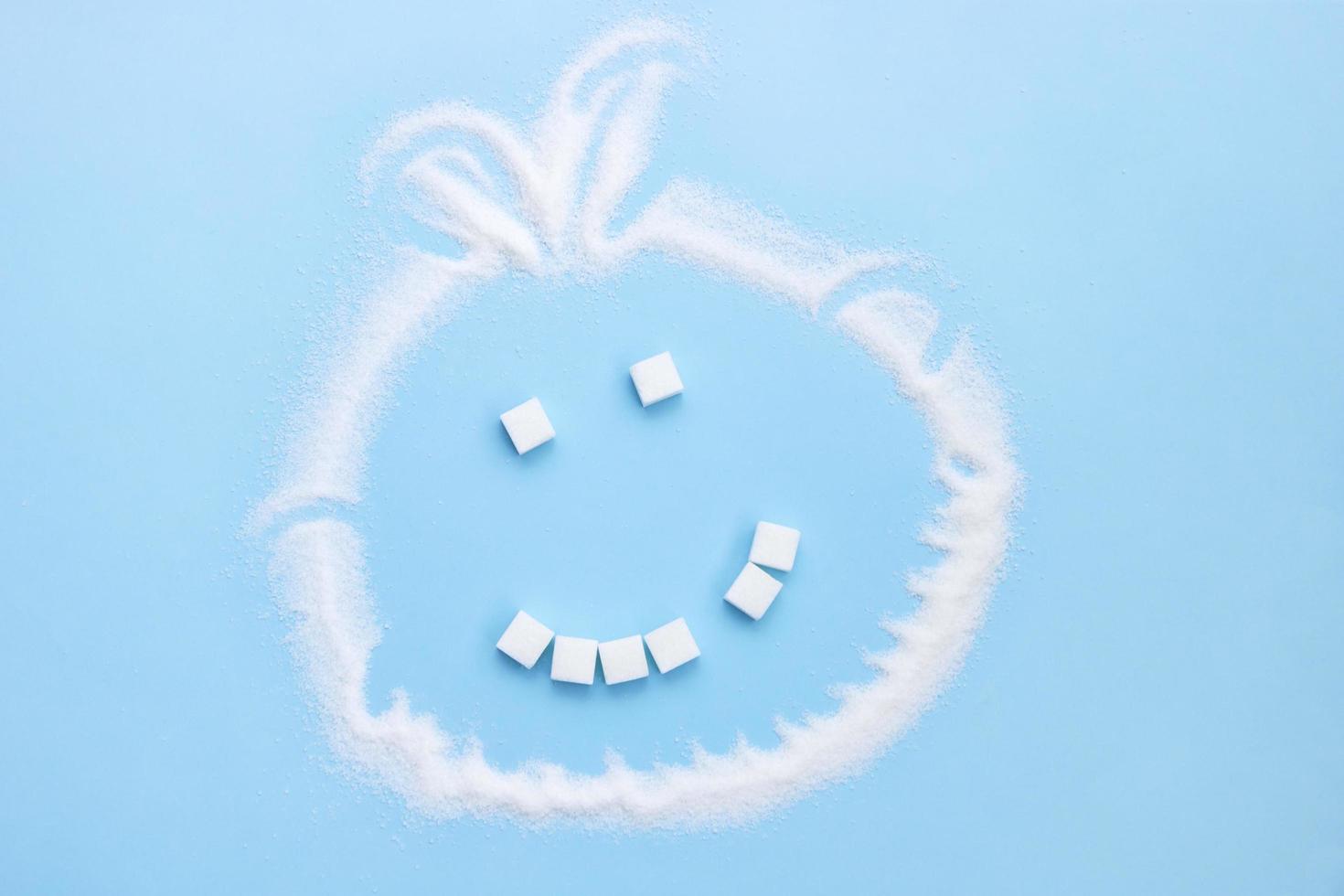sugar face smile from sugar cubes without one tooth on a blue background, junk food photo