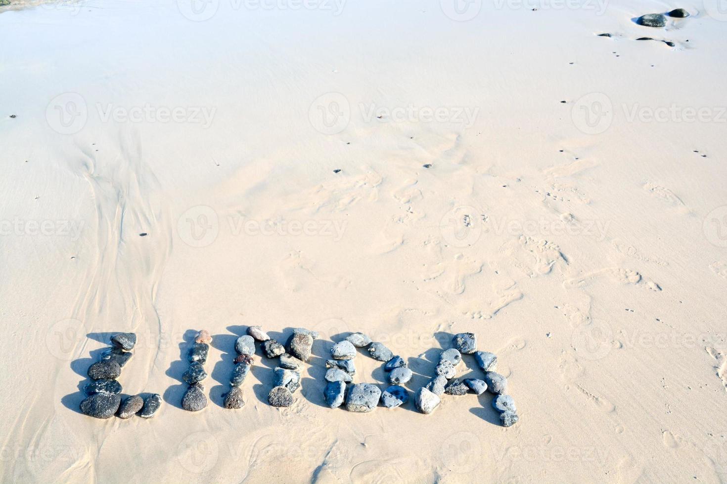 Letters on dry sand near the water photo