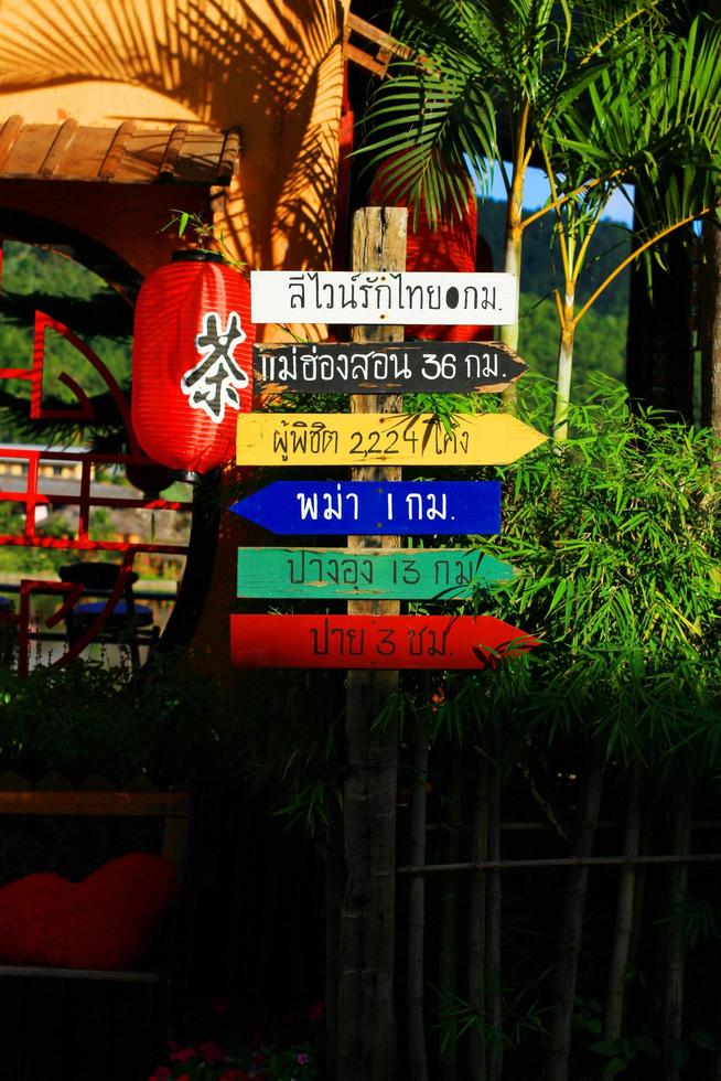 tailandés idioma en vistoso de madera señales para direcciones a varios lugares en Tailandia foto