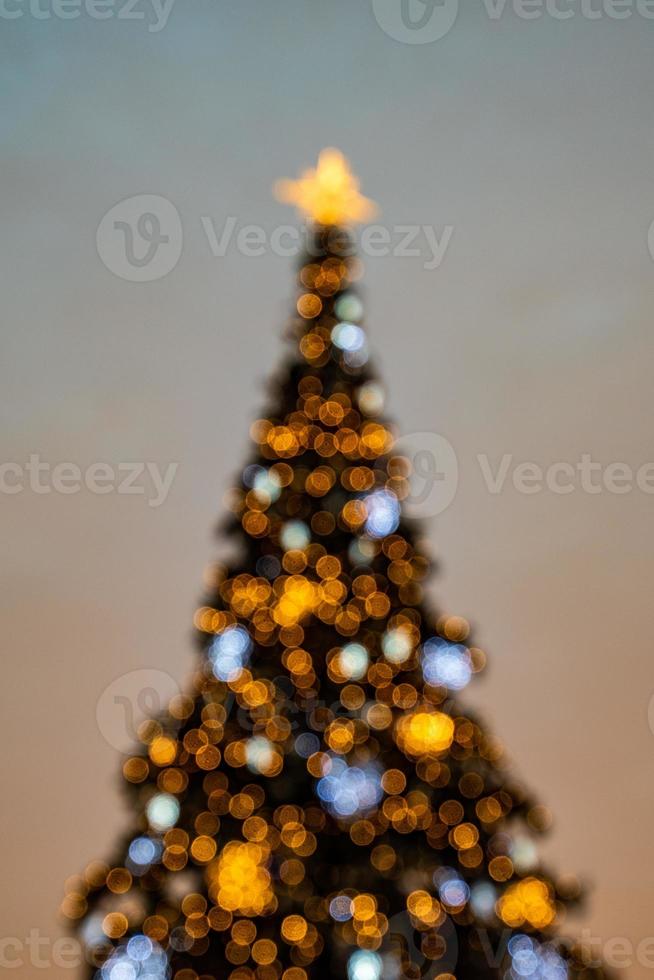 colorful Christmas tree shimmering against the background of the evening pastel sky photo