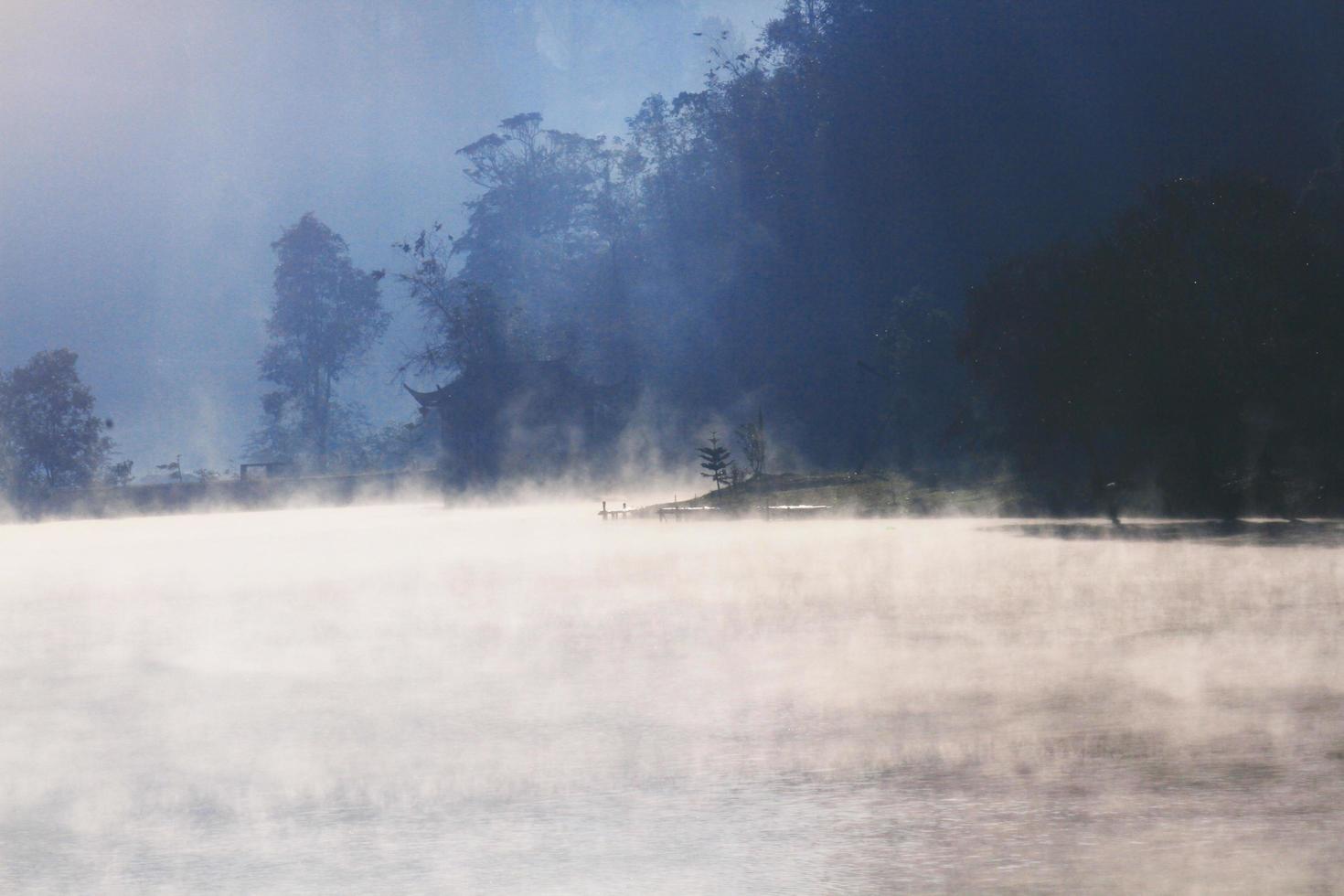 Beautiful landscape heaven of mist and fog over the lake and sunrise shining with blue sky reflection on the water surface at Hill tribe village on mountain in Thailand photo