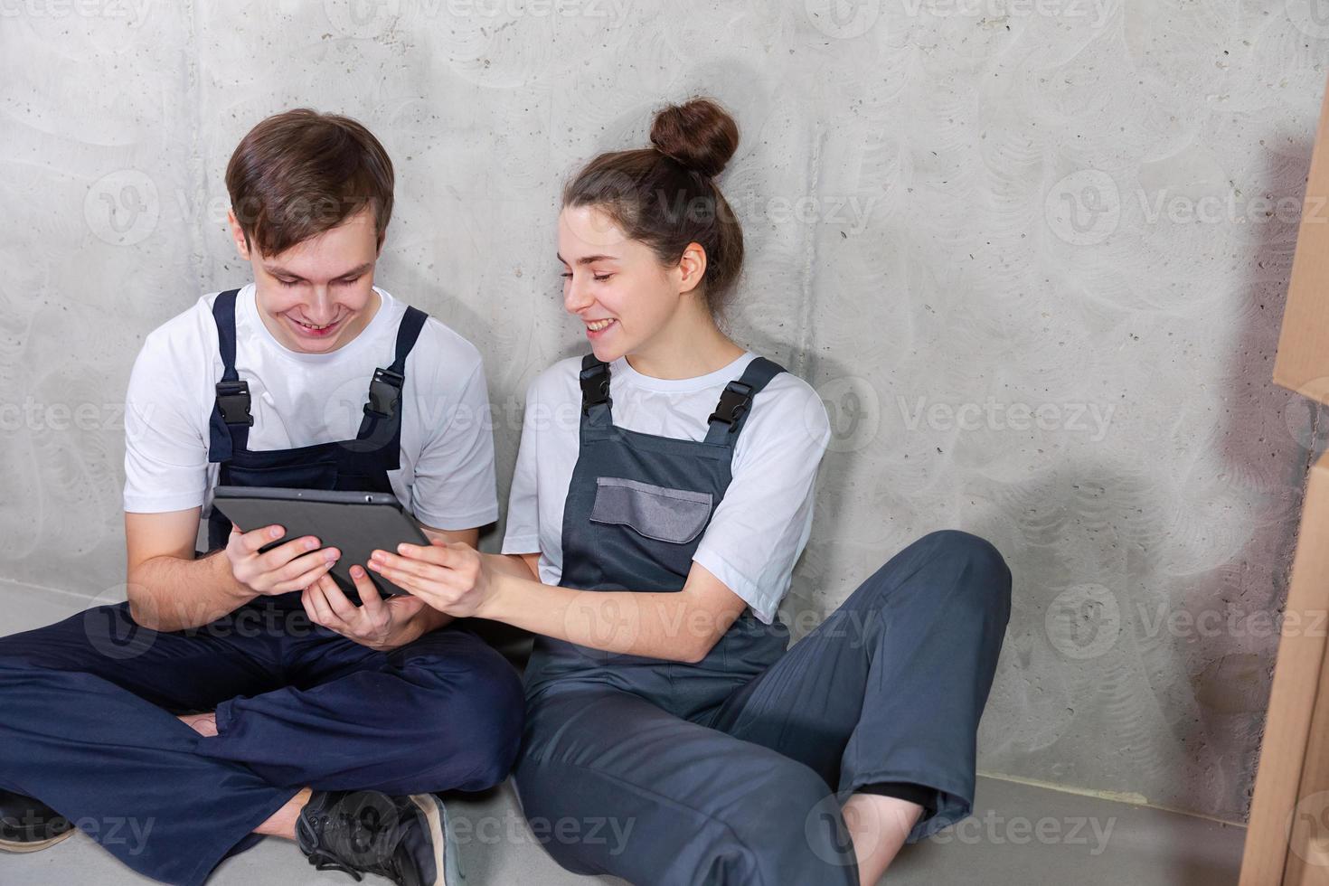 Couple in new home during repair works discussing about home design project looking repair plan on tablet. Happy family choosing new decorations and design. Home renovation DIY renew makeover concept. photo