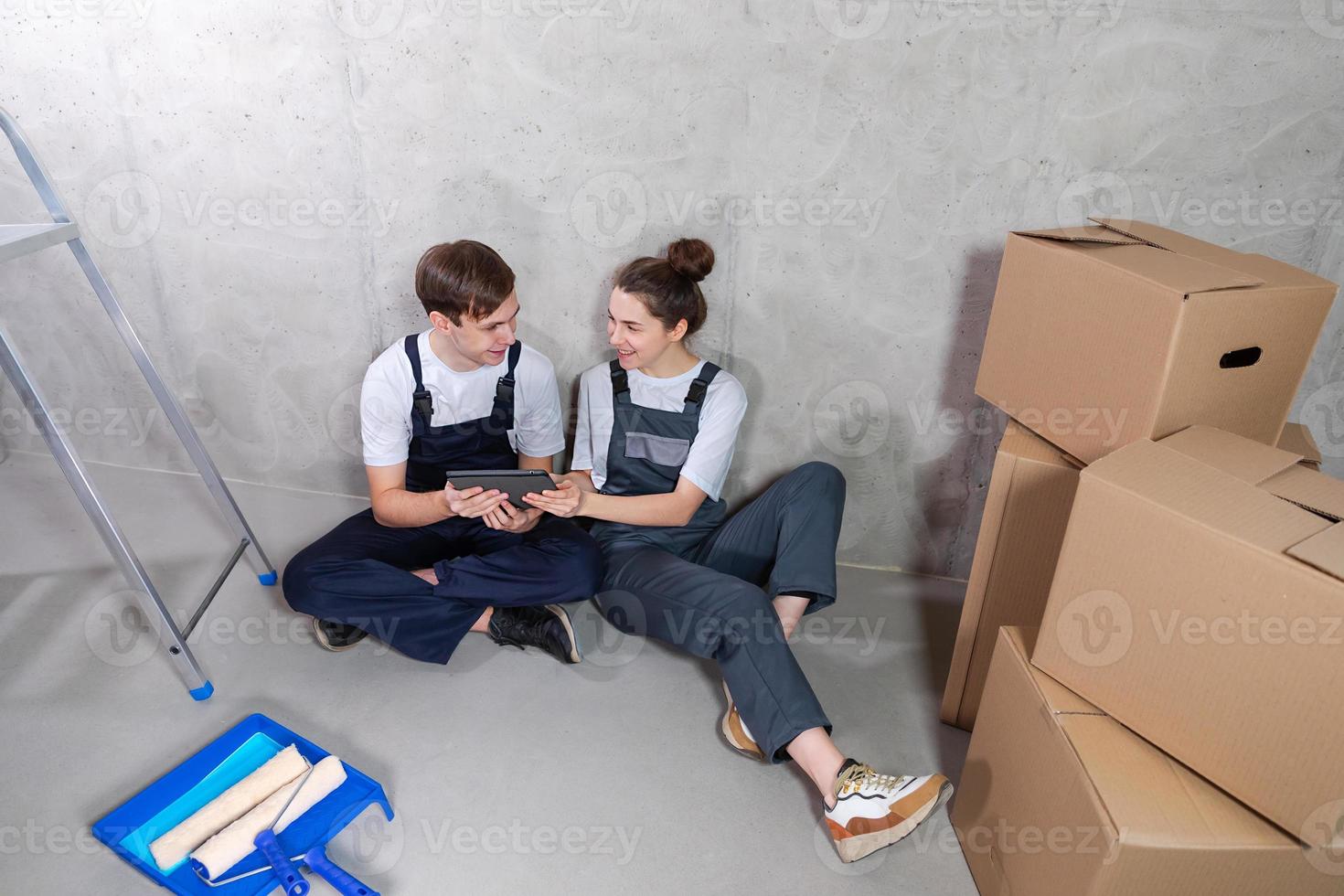 Couple in new home during repair works discussing about home design project looking repair plan on tablet. Happy family choosing new decorations and design. Home renovation DIY renew makeover concept. photo
