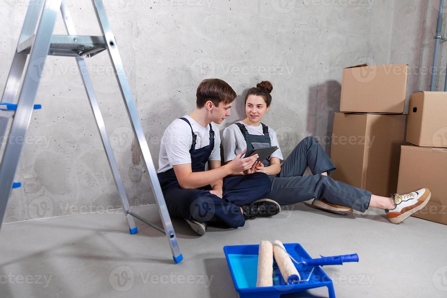 Couple in new home during repair works discussing about home design project looking repair plan on tablet. Happy family choosing new decorations and design. Home renovation DIY renew makeover concept. photo