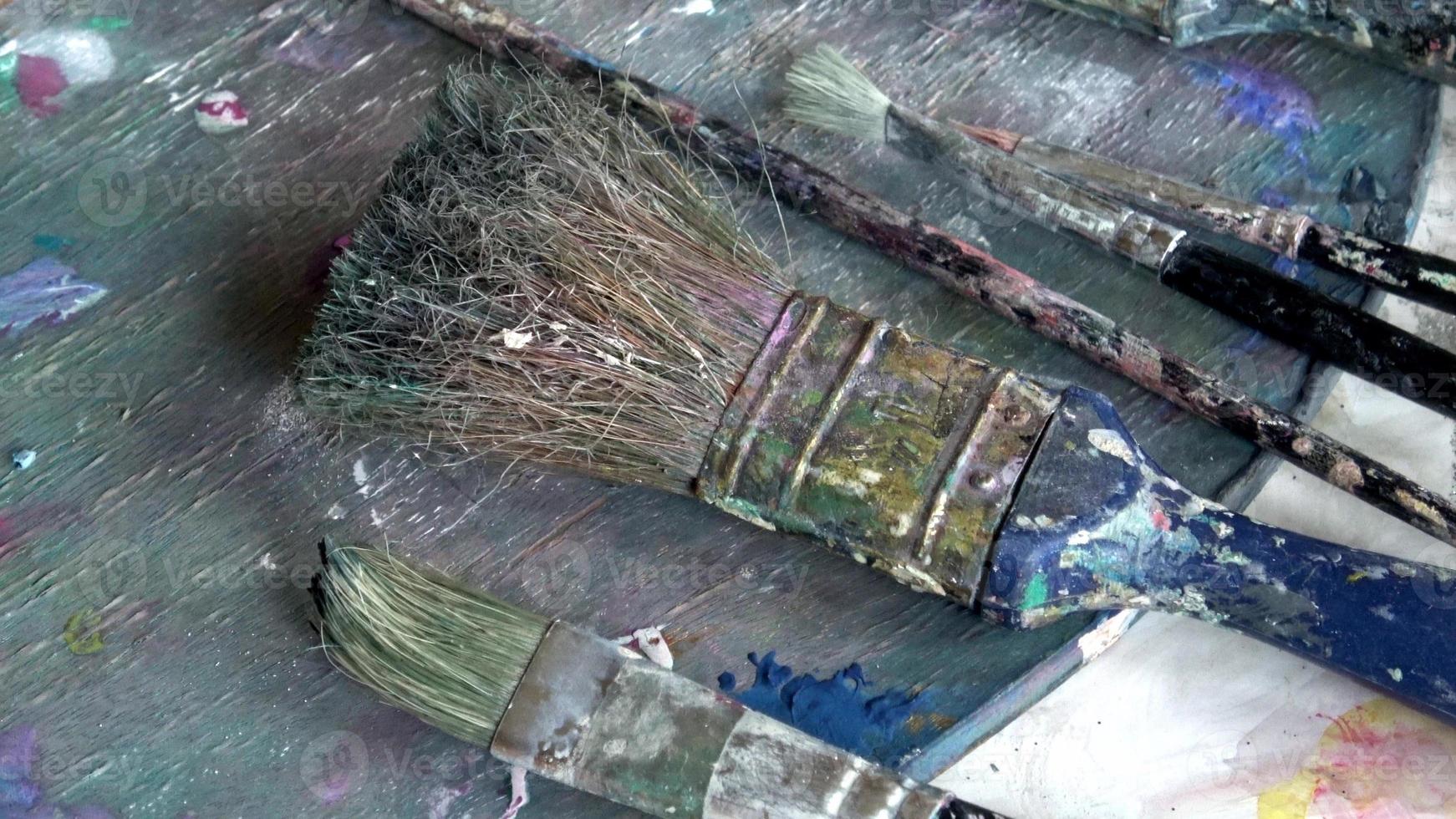 Used brushes on an artist's palette of colorful oil paint photo