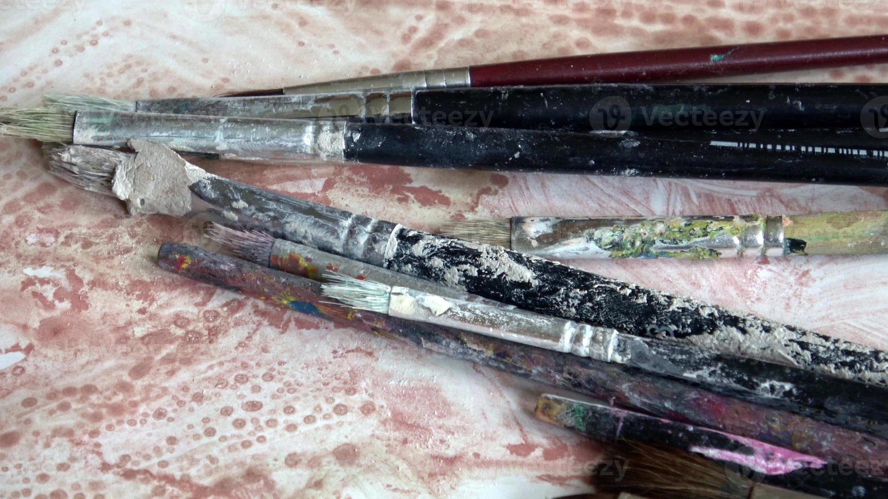 Used brushes on an artist's palette of colorful oil paint photo