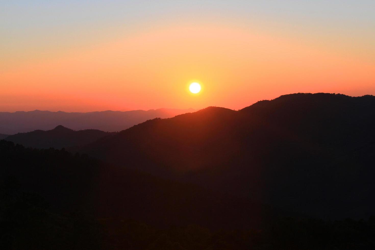 Sunset in sky and cloud, beautiful colorful twilight time with silhouette of mountain. photo