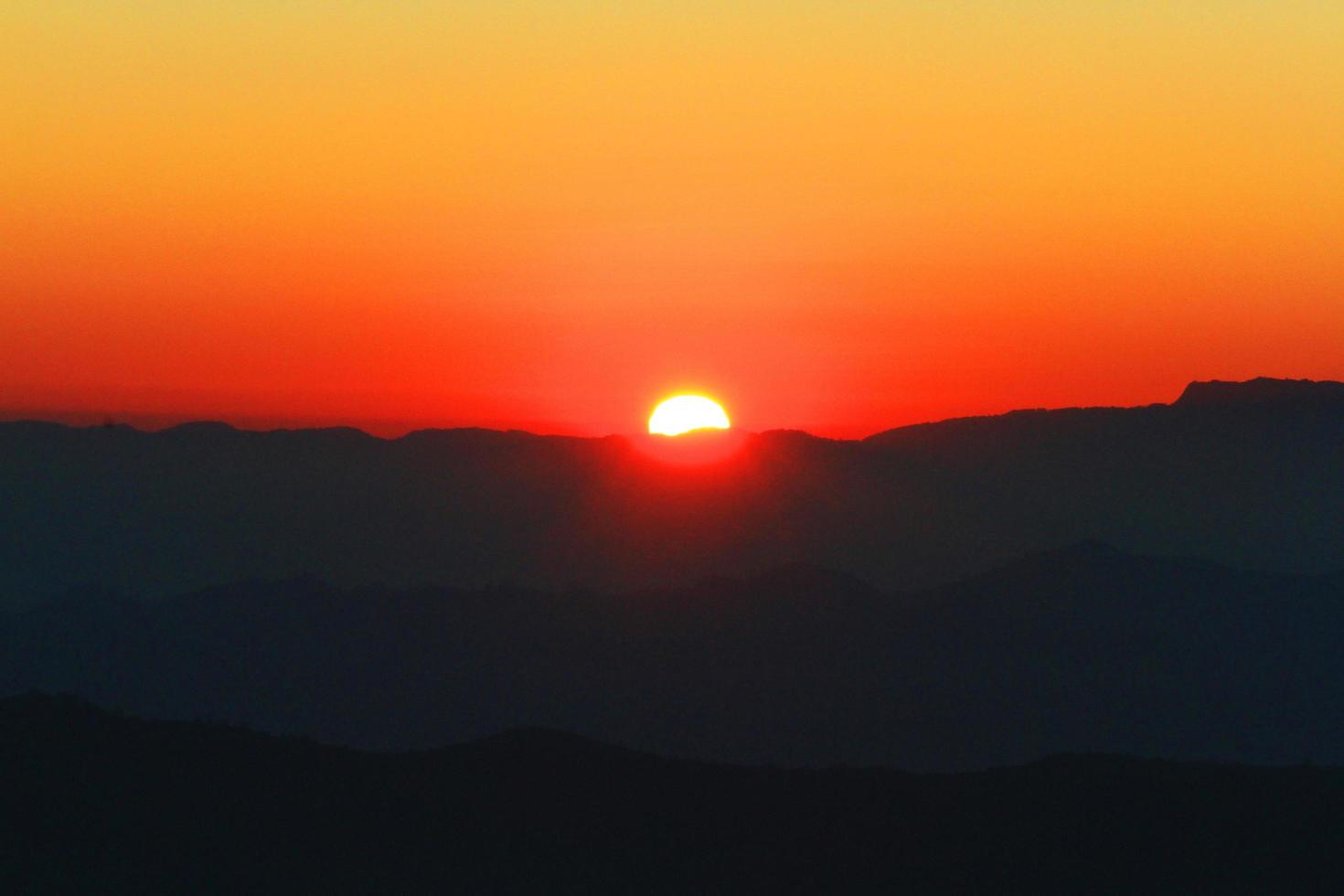 Sunset in sky and cloud, beautiful colorful twilight time with silhouette of mountain. photo