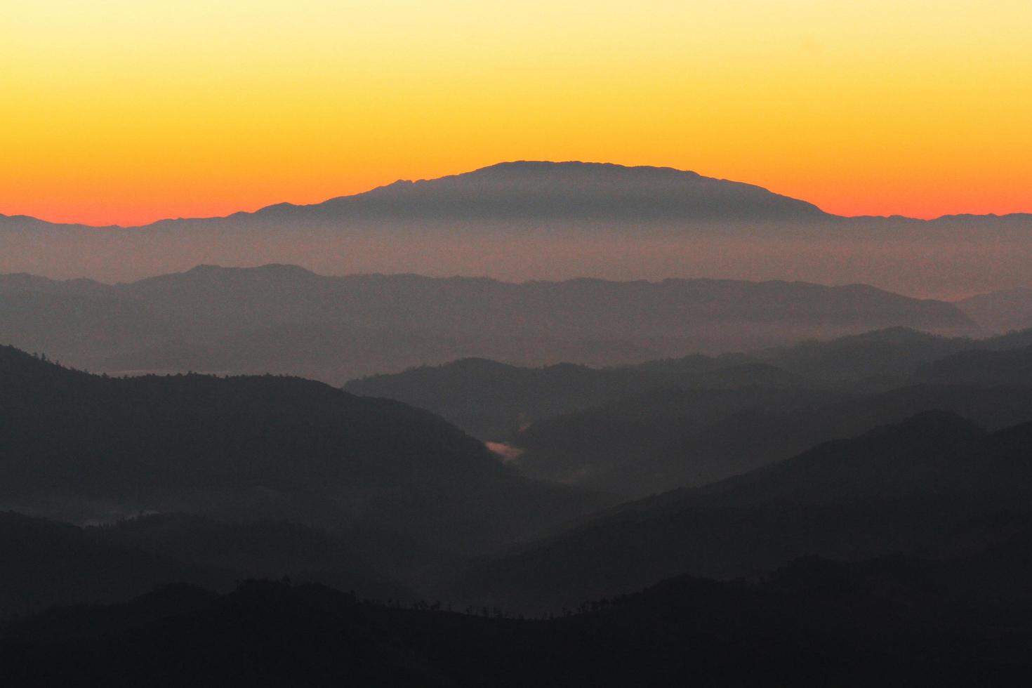 Sunset in sky and cloud, beautiful colorful twilight time with silhouette of mountain. photo