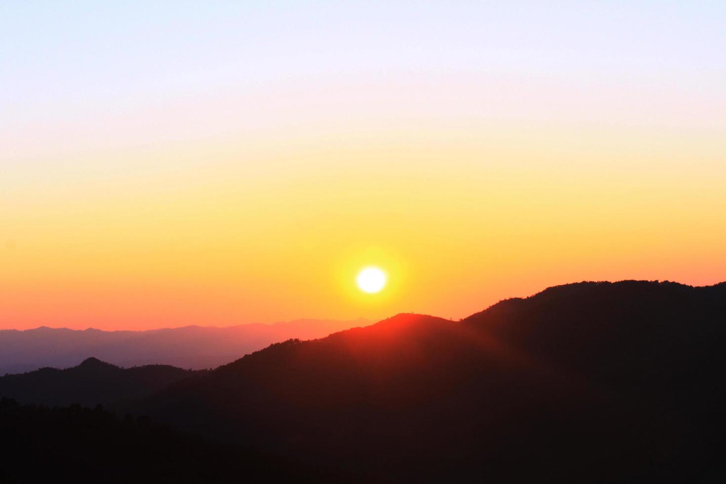 puesta de sol en cielo y nube, hermosa vistoso crepúsculo hora con silueta de montaña. foto