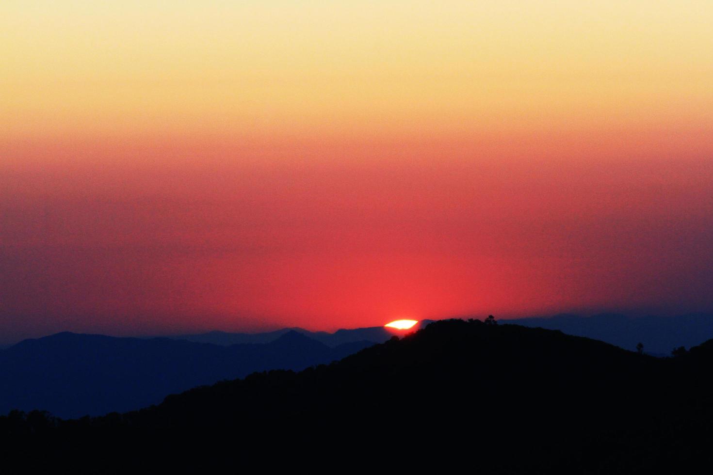 puesta de sol en cielo y nube, hermosa vistoso crepúsculo hora con silueta de montaña. foto