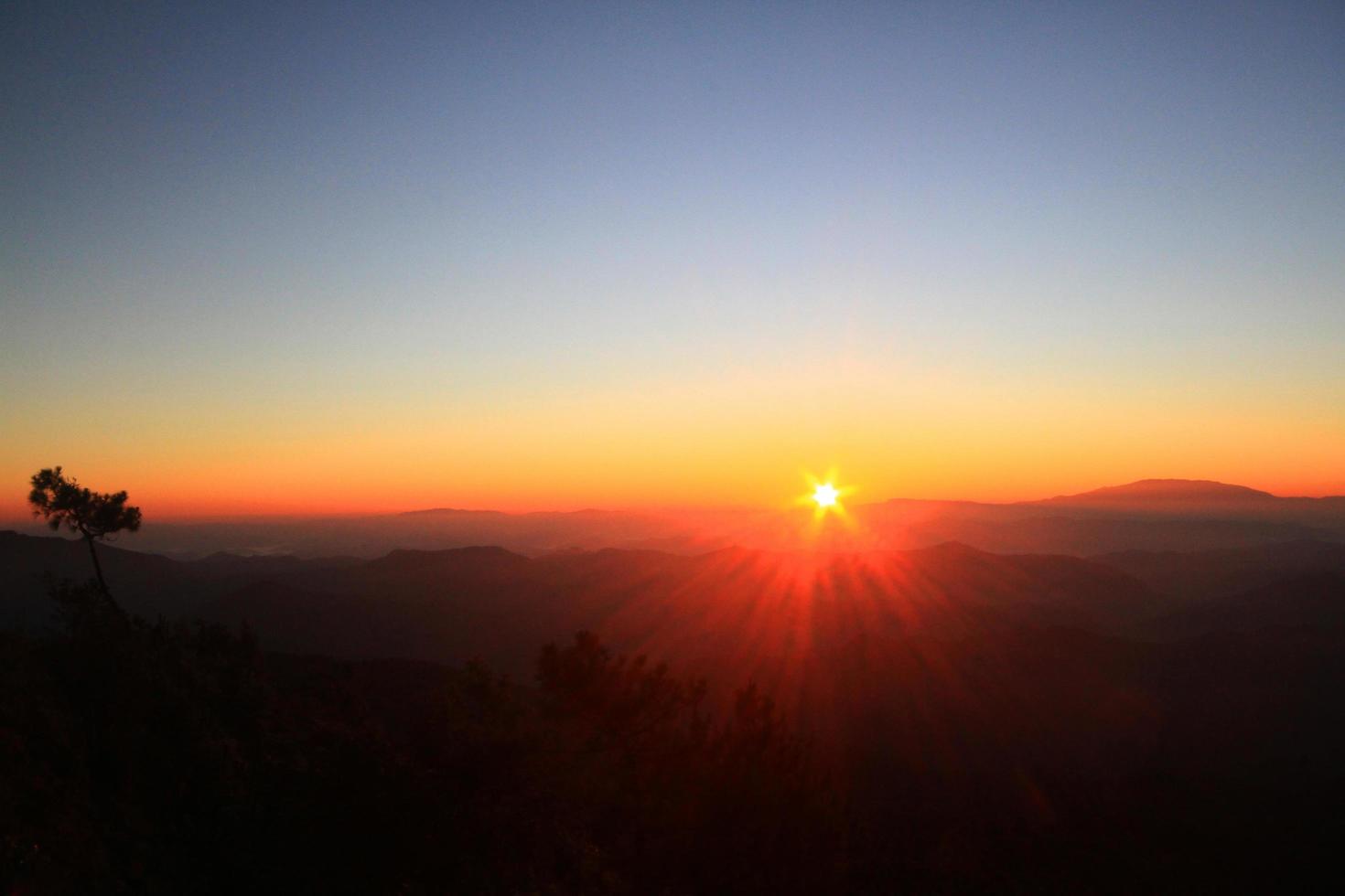 Beautiful golden natural sunlight and twiligh of sunrise shining to in the mist on valley of mountain in Thailand photo
