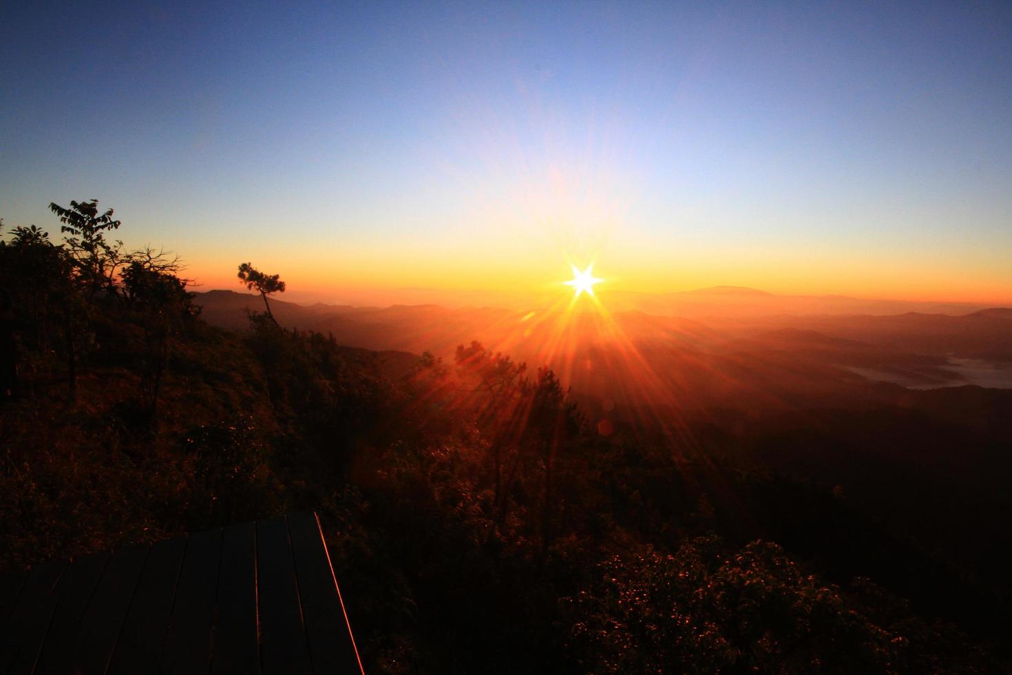 Beautiful golden natural sunlight and twiligh of sunrise shining to in the mist on valley of mountain in Thailand photo