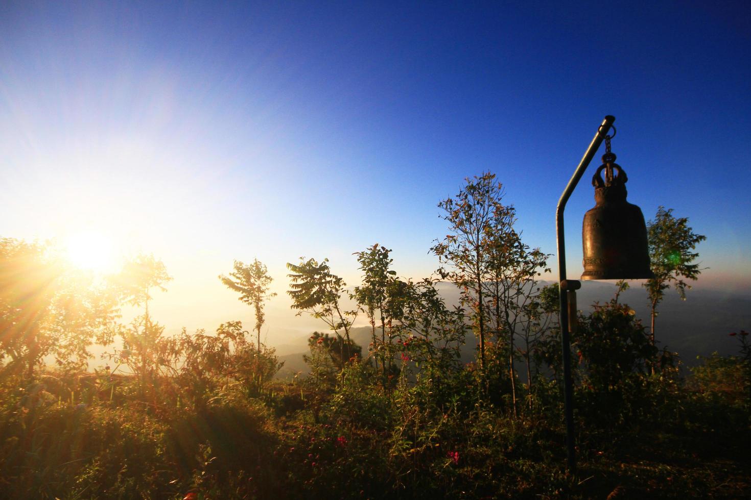 Beautiful silhouette of golden bell in twilight of sunrise with wild and forest on the valley mountain photo