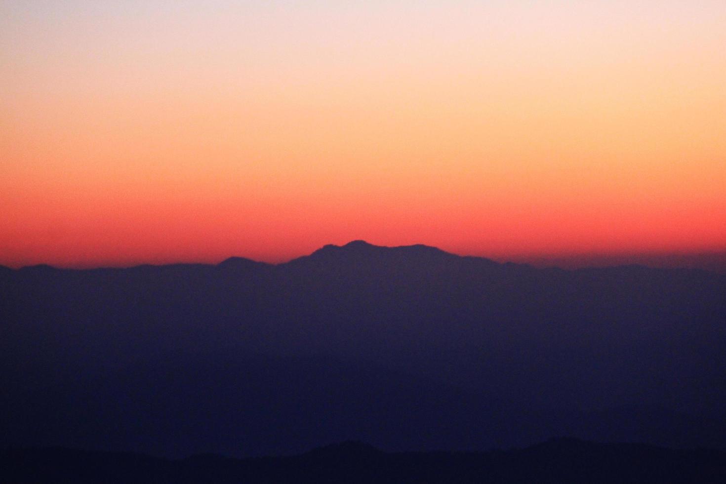 Sunset in sky and cloud, beautiful colorful twilight time with silhouette of mountain. photo