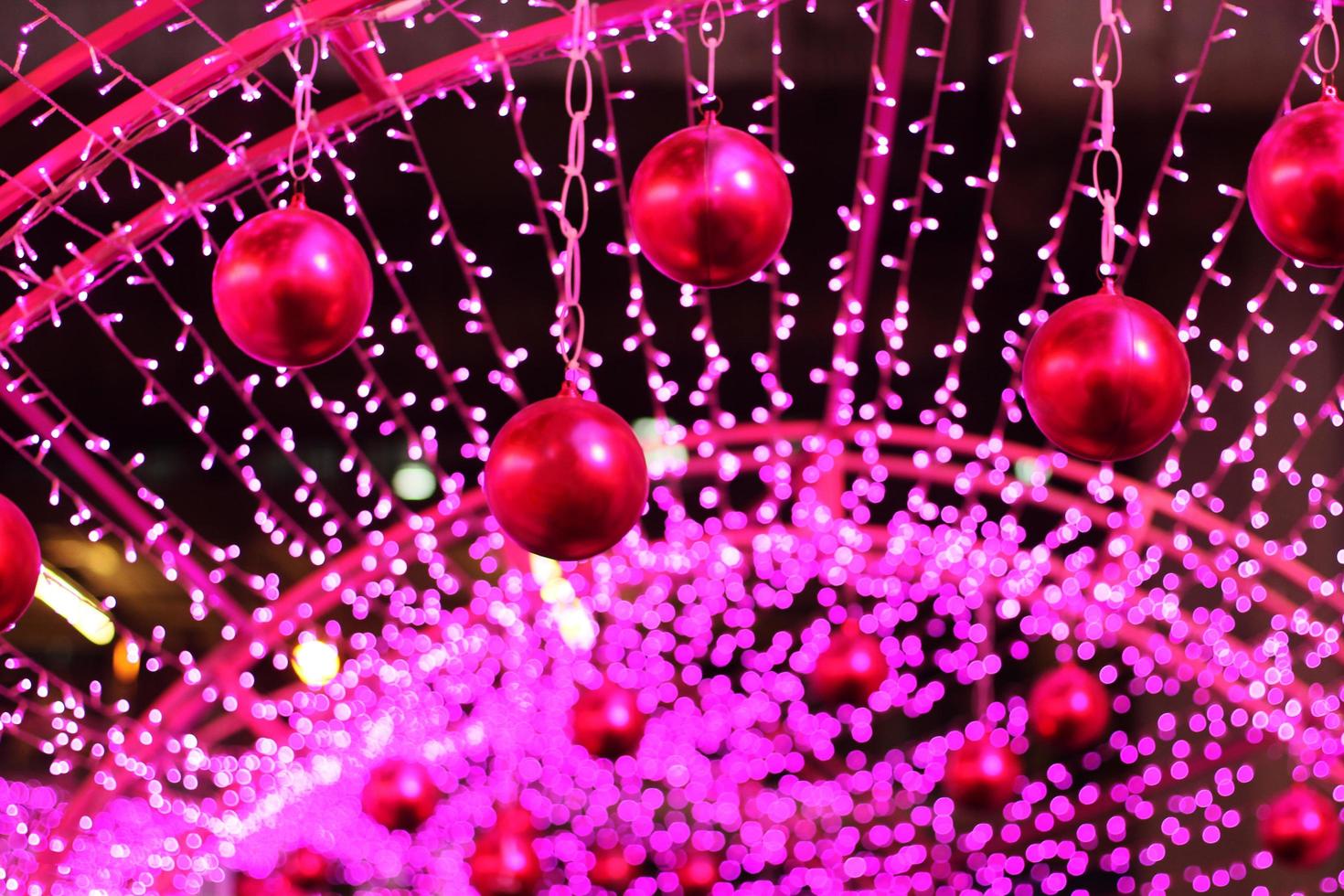 Red ball in Glamour Ultra Violet sparkling and purple glitter bokeh of metallic circle. Multicolored Christmas and New Year glowing light abstract for Christmas and holiday concept. photo