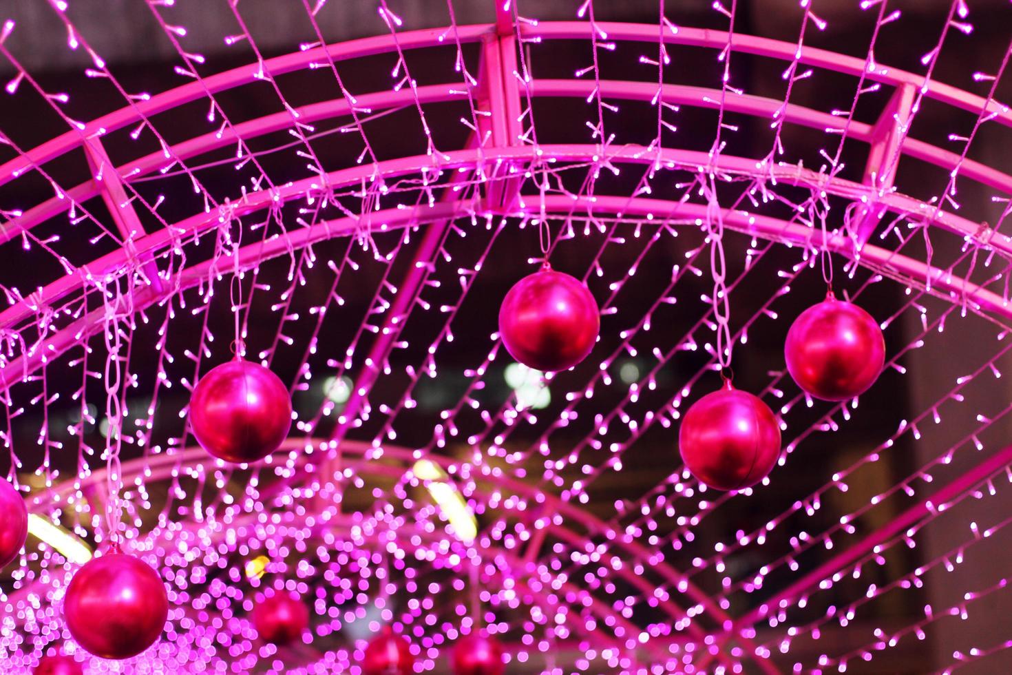 Red ball in Glamour Ultra Violet sparkling and purple glitter bokeh of metallic circle. Multicolored Christmas and New Year glowing light abstract for Christmas and holiday concept. photo