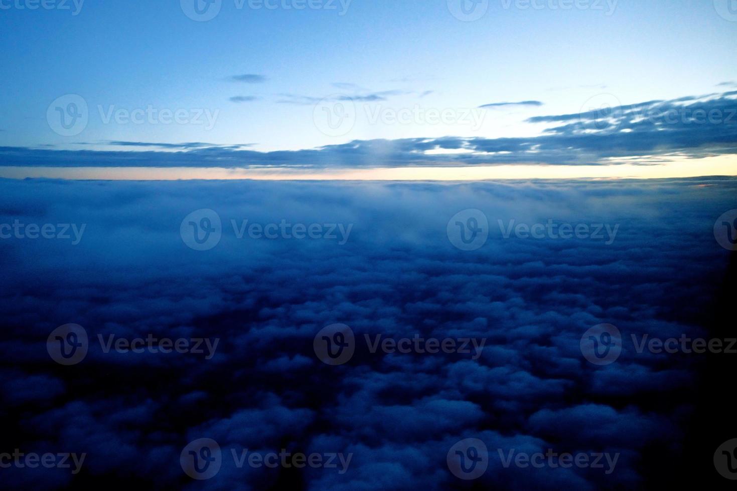 original sunrise landscape over dark clouds seen from the window of an aircraft photo