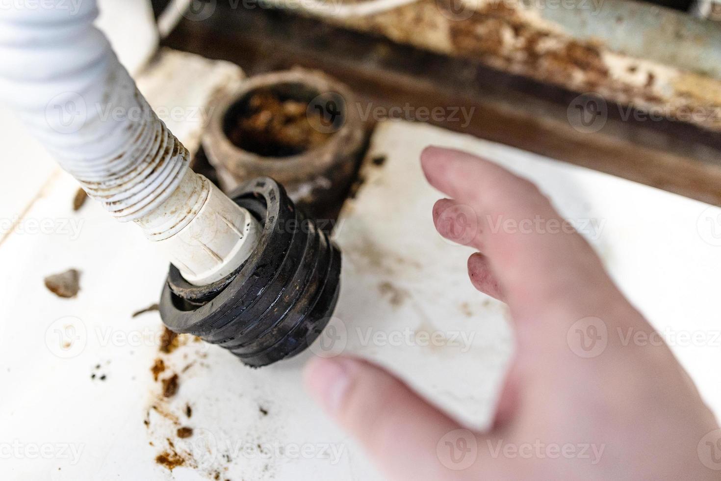hand of plumber near corrugated drain hose closeup photo