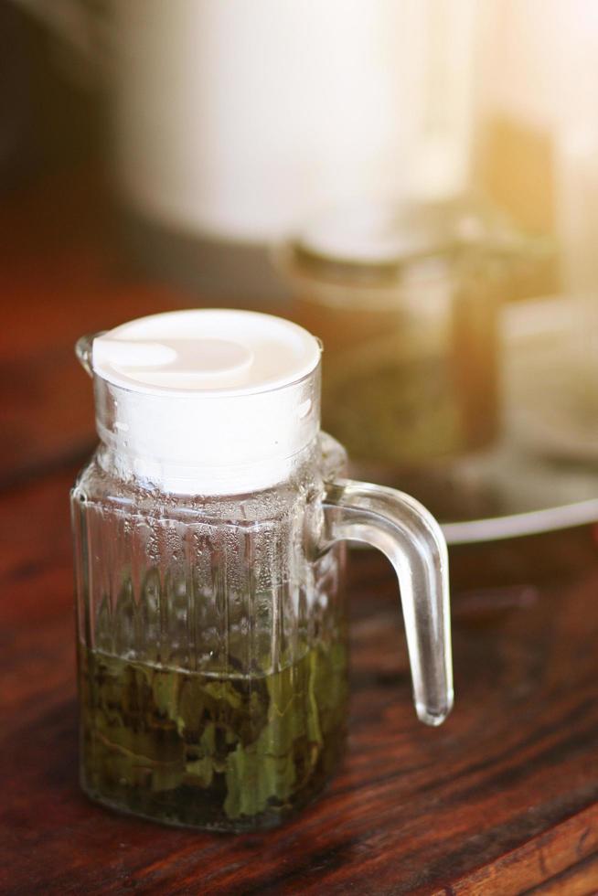 Hot Green tea leaves are boiled in a glass jar. photo