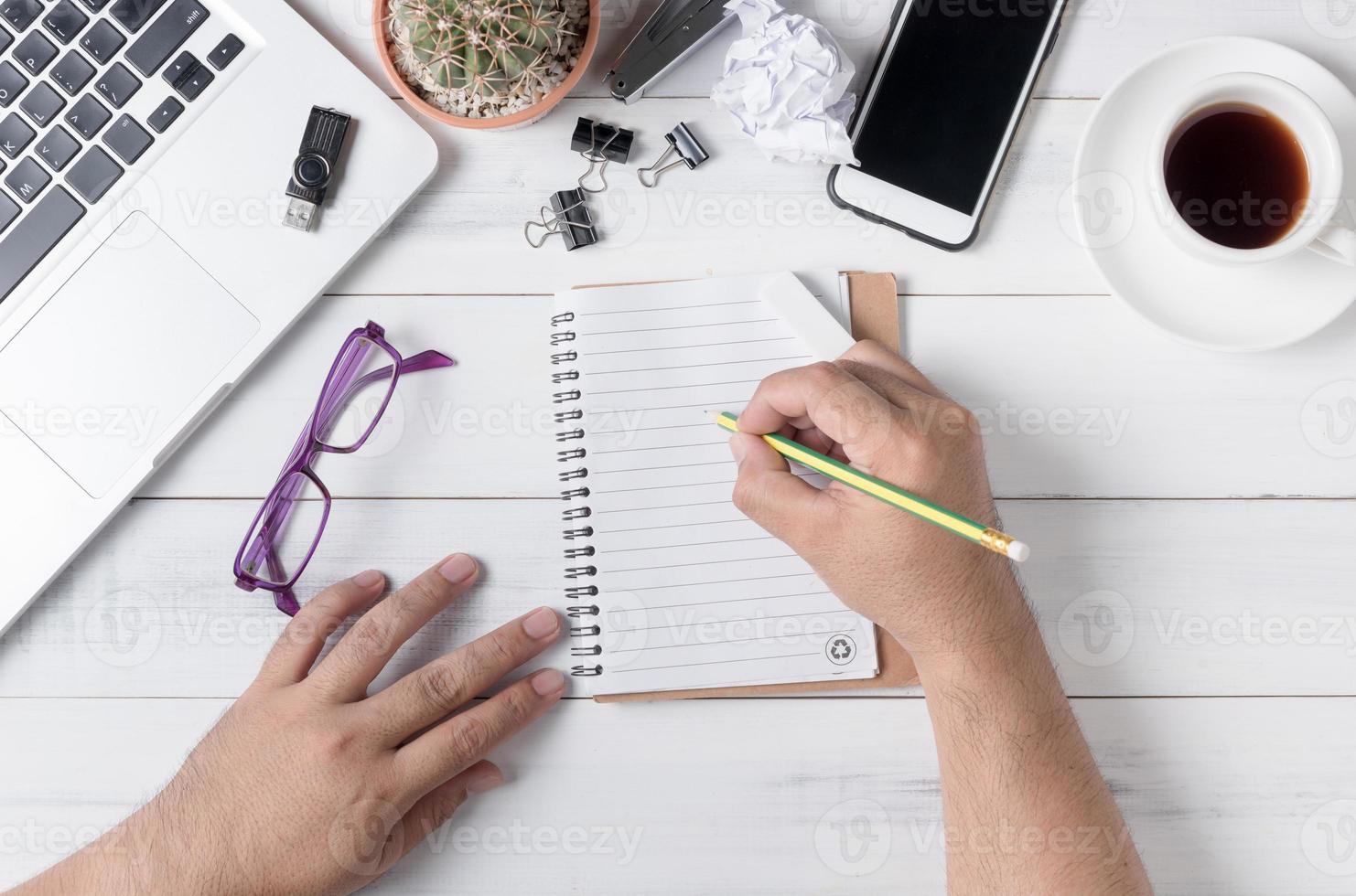 negocio mano hombre escritura en blanco cuaderno en mesa, foto