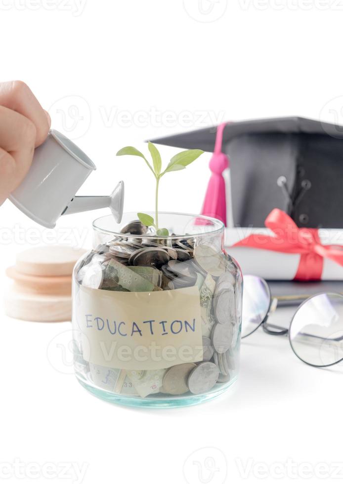 girl hand watering a tree growing out of silver coins photo