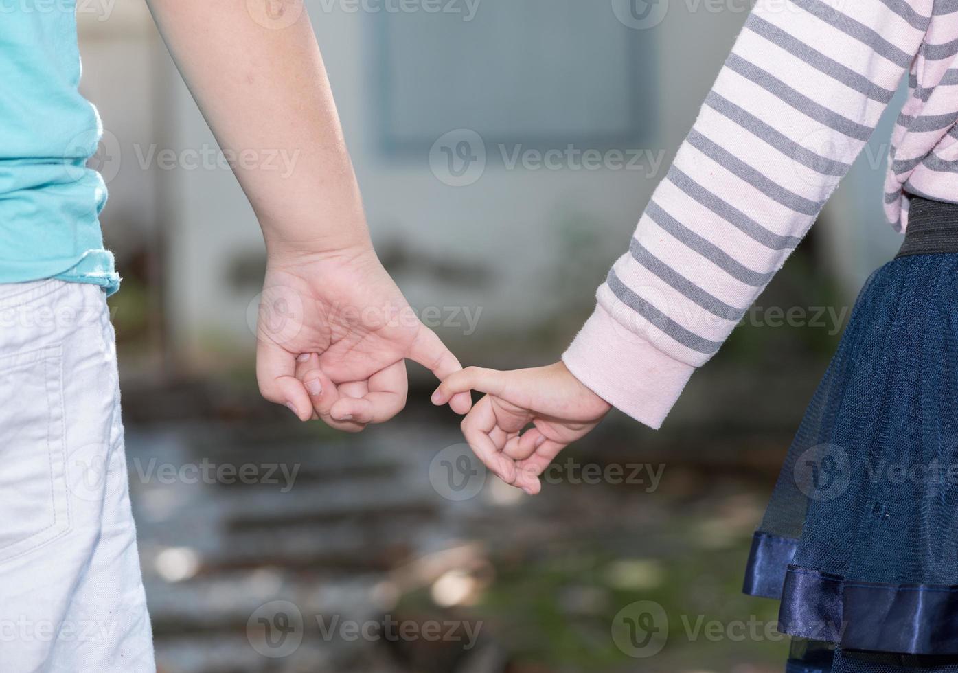 Brother and sisters holding hand in hand photo