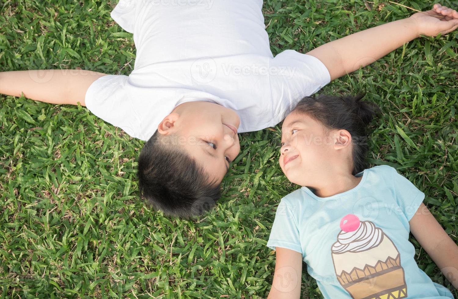Smile children lie down on grass photo