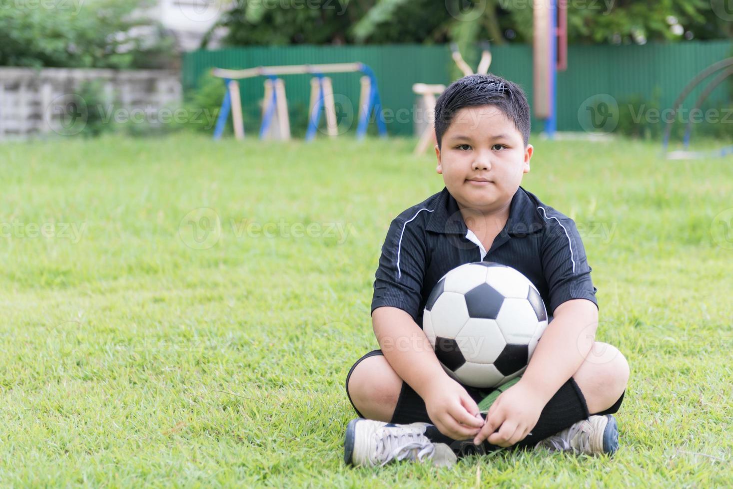 sitting obese fat boy  soccer player with football photo