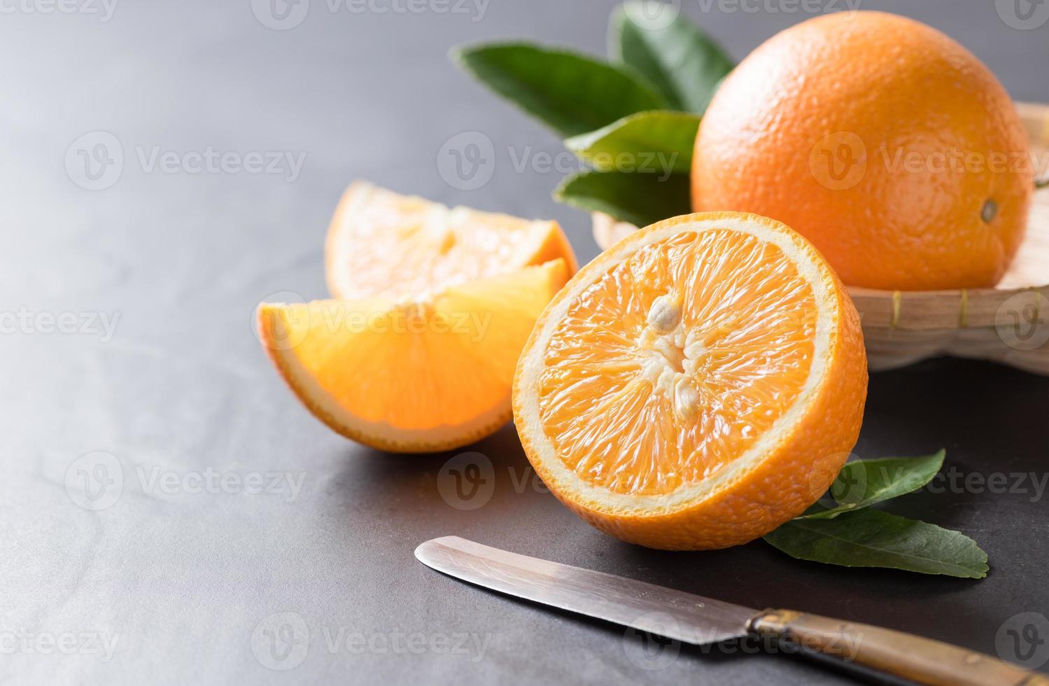 Fresco rebanado naranja en negro Roca antecedentes. foto