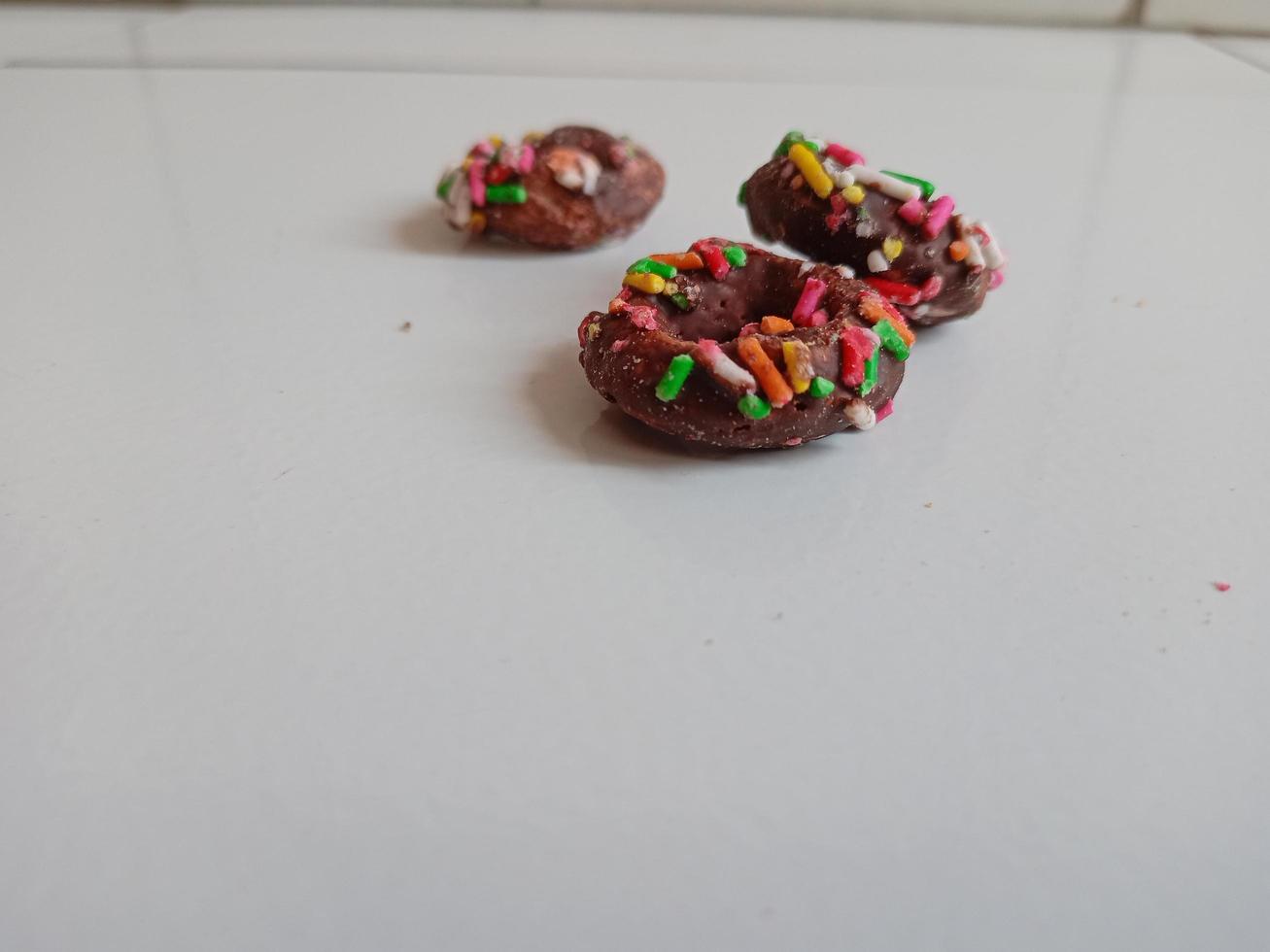 Close up of glazed doughnuts with bright colored sprinkles,isolated on a white background. photo