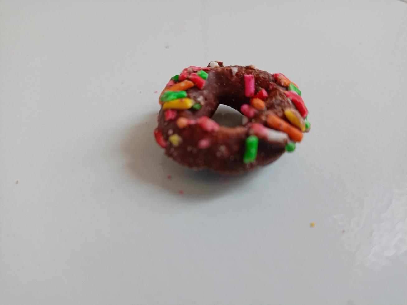 Close up of glazed doughnuts with bright colored sprinkles,isolated on a white background. photo