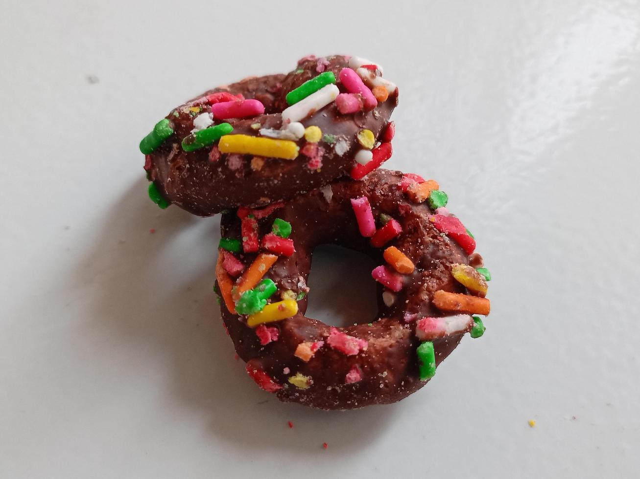 cerca arriba de vidriado rosquillas con brillante de colores rocía,aislado en un blanco antecedentes. foto