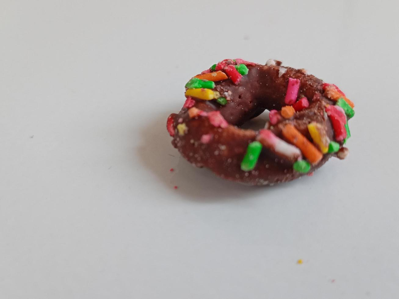 cerca arriba de vidriado rosquillas con brillante de colores rocía,aislado en un blanco antecedentes. foto