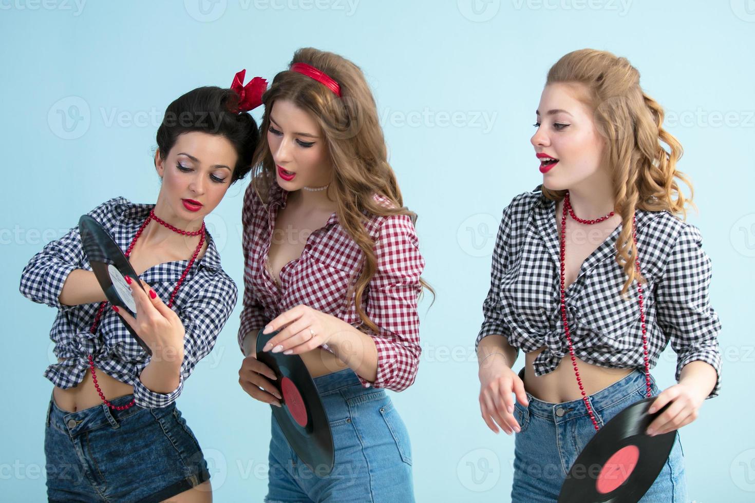 Three retro girls with vinyl records. photo