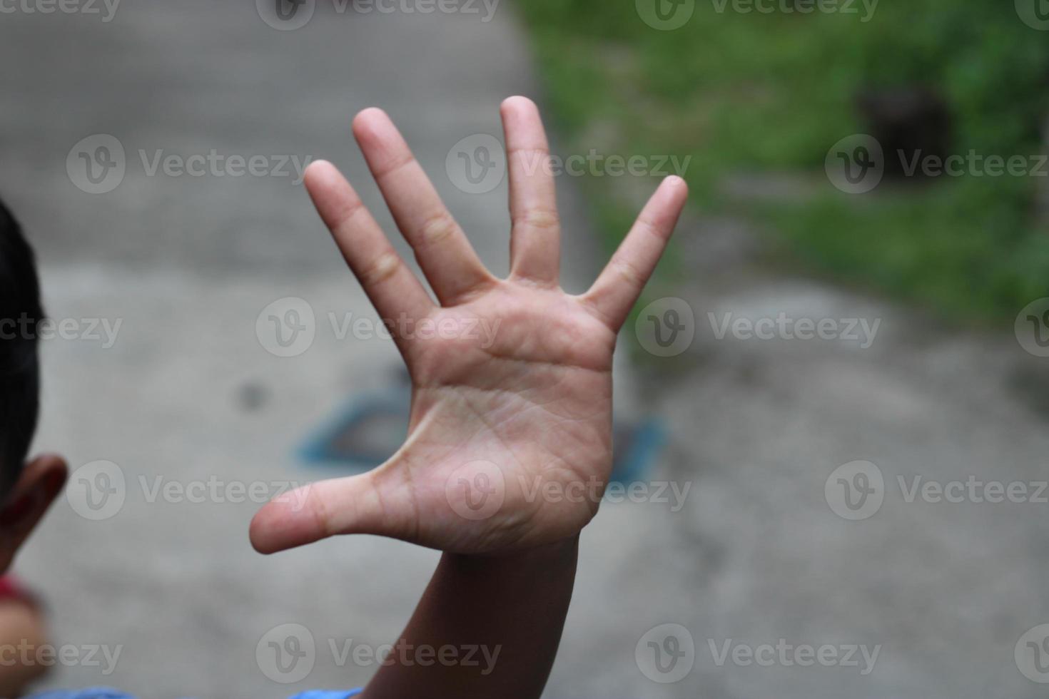 photo of hand waving outside the street